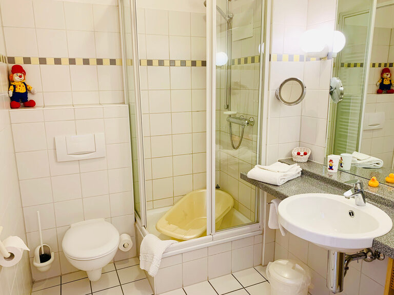 Helles Badezimmer für Familien mit Dusche und Waschbecken