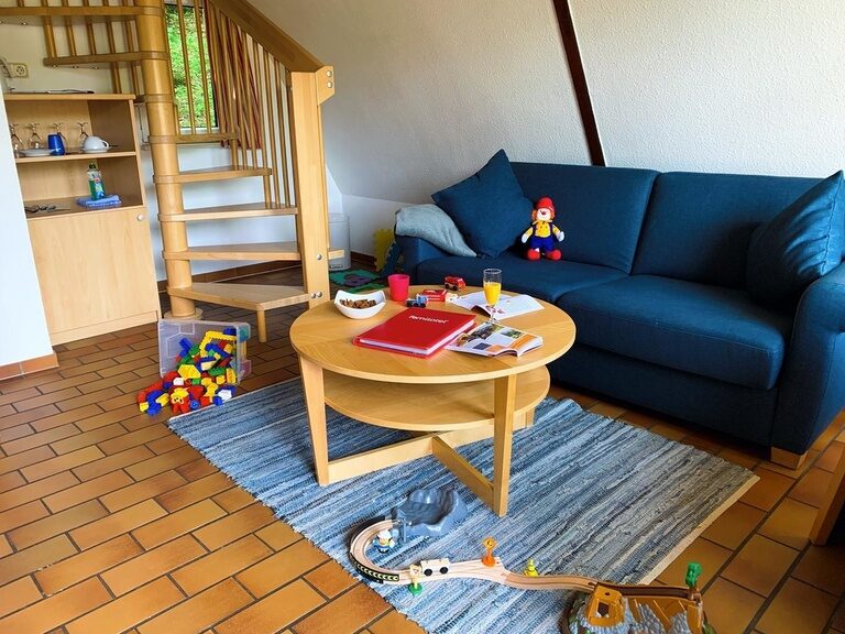 Couch unter Dachschräge mit Tisch in Ferienwohnung