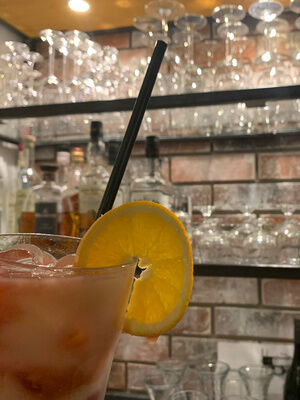 Cocktail mit Eiswürfeln und Orangenscheibe