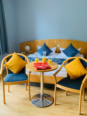 Hotelzimmer mit Doppelbett und Sitzgelegenheit