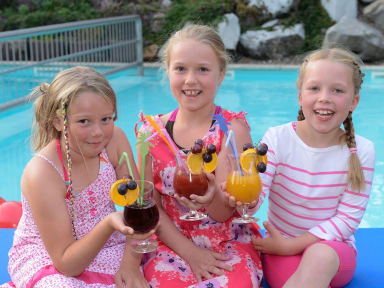 Drei Mädchen am Pool mit Kindercocktail
