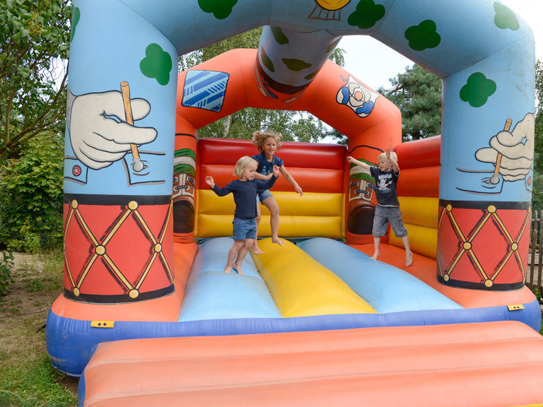 Kinder spielen auf Hüpfburg