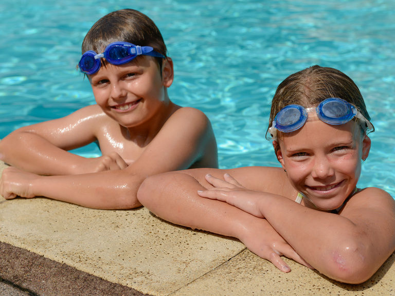 Zwei Kinder im Pool mit Schwimmbrille