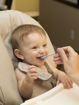 Baby wird mit Löffel gefüttert