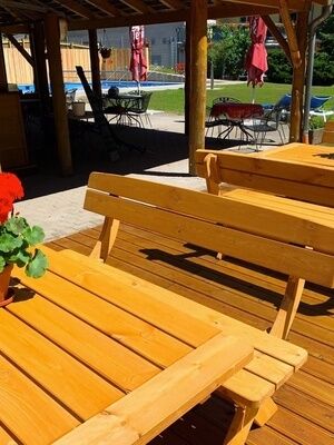 Sitzmöglichkeit außen mit Holztischen und Sonnenschirmen