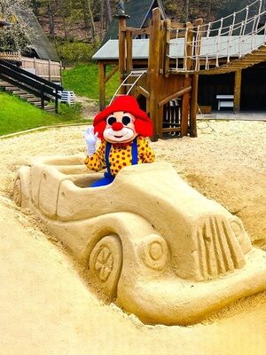 Happy in einem Sandauto im Sandkasten