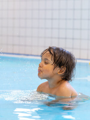 Kind schwimmt im Pool im Family Club Harz