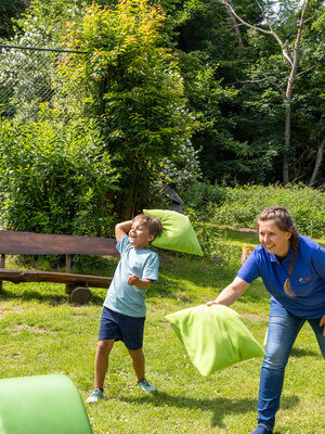 Kinder spielen mit Kissen auf einer Wiese