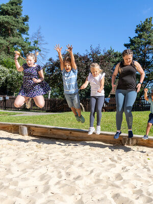 Familie hüpft gemeinsam in einem Sandkasten