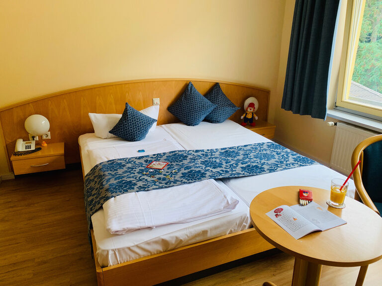 Doppelbett neben Fenster im Hotelzimmer