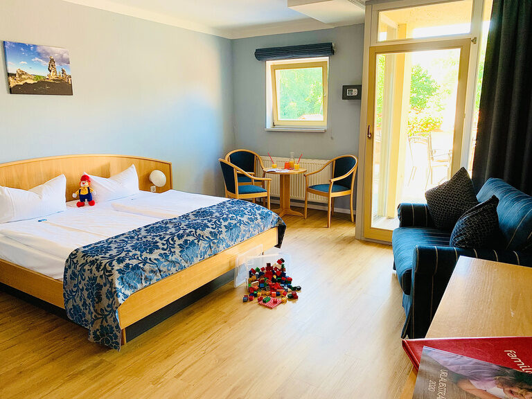 Gemütliches Schlafzimmer mit Doppelbett und Blick aus dem Fenster.
