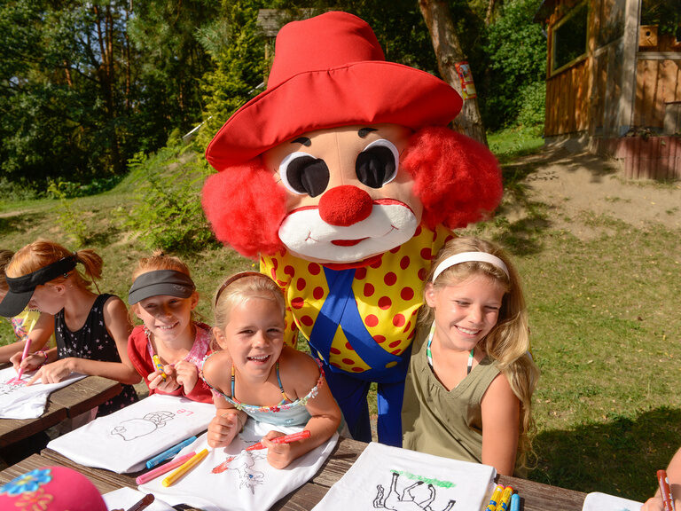 Clown Happy mit Kindern draußen am Malen
