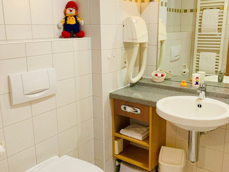 Helles Badezimmer mit Dusche und Waschbecken.