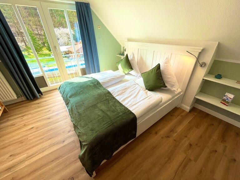 Helles Schlafzimmer im Ferienhaus mit Doppelbett und großem Fenster
