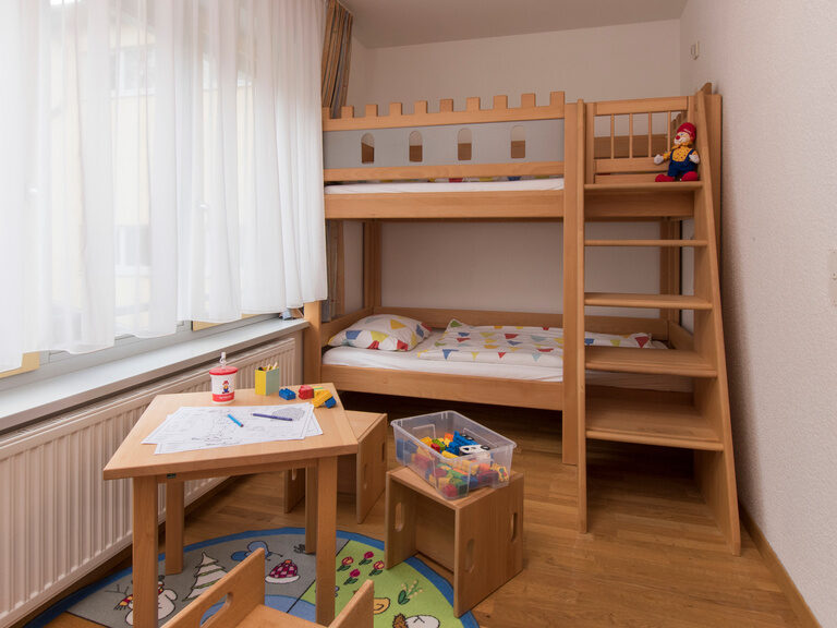 Hochbett aus Holz und Spielecke in einer Unterkunft im Family Club Harz.