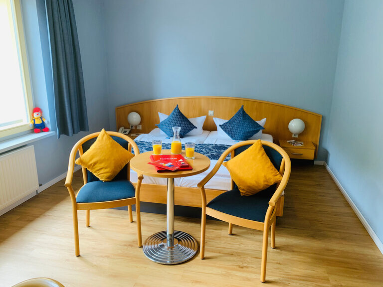 Hotelzimmer mit Doppelbett und Sitzgelegenheit