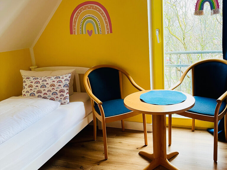 Kinderzimmer mit Doppelstockbett und gelb gestrichener Wand in einer Unterkunft des Family Club Harz.