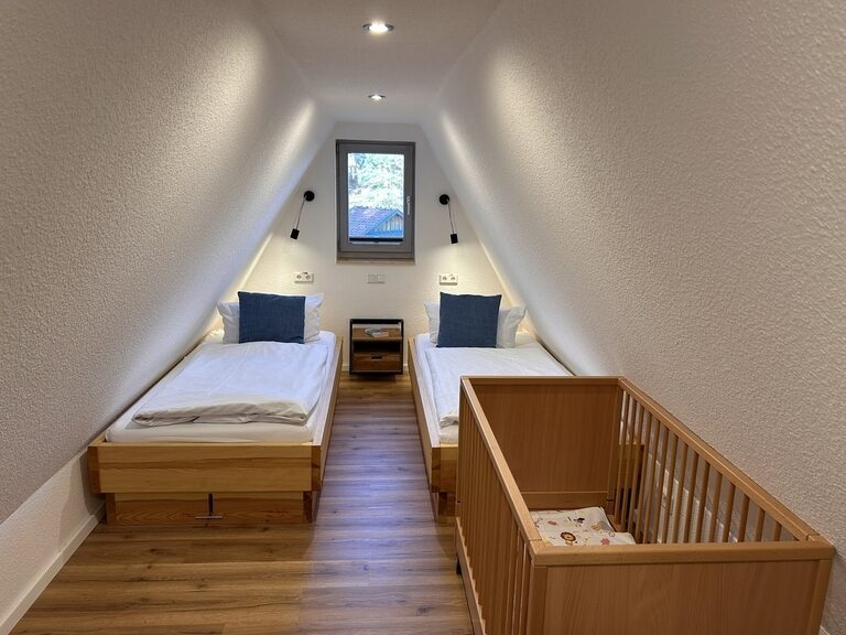 Kinderzimmer in Familienappartment mit Gitterbett für Baby