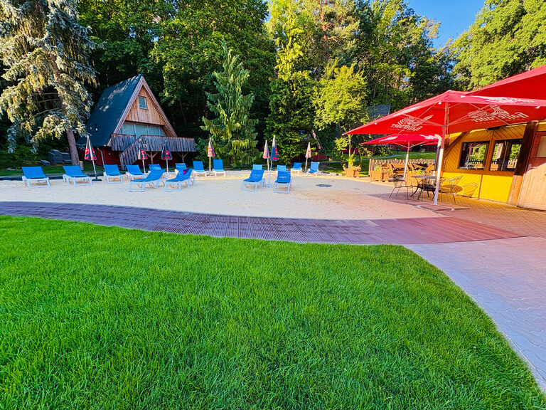 Liegebereich mit Liegestühlen und Sand im Außenbereich des Family Club Harz
