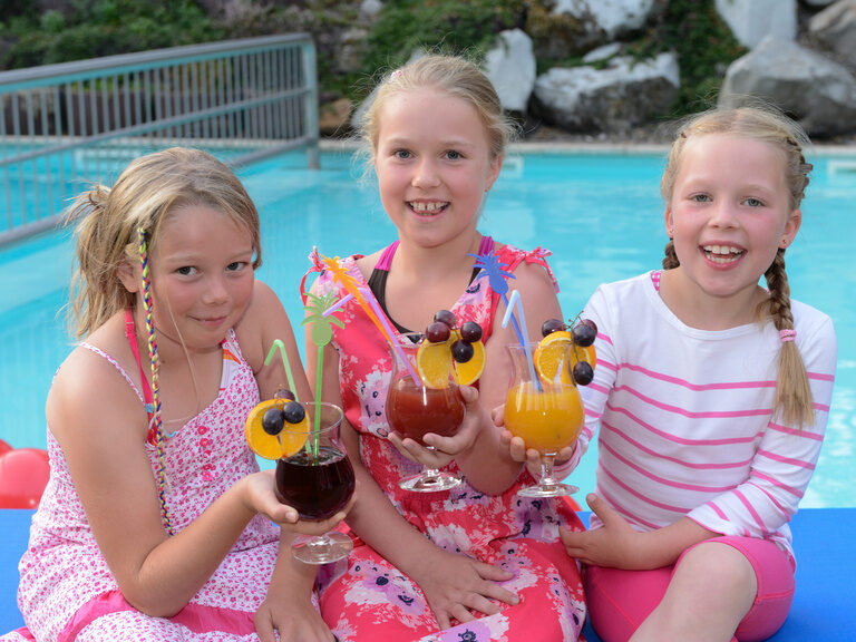 Drei Mädchen am Pool mit Kindercocktail