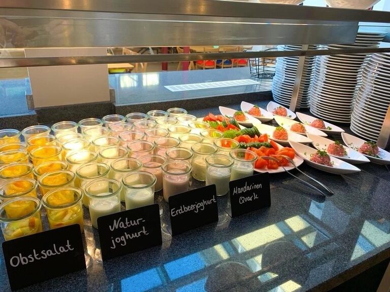 Obstsalat und Joghurt beim Frühstücksbuffet