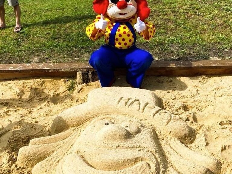 Sandskulptur Happy mit Maskottchen Happy