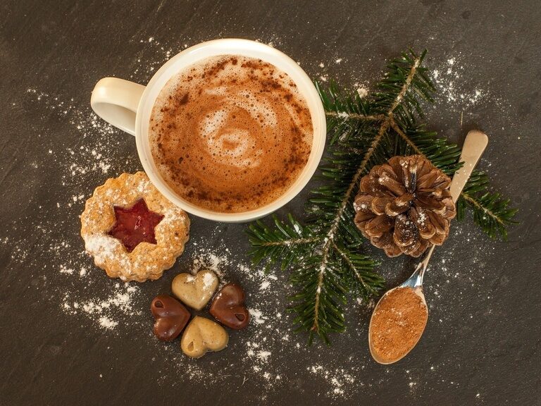 Weihnachtliche Kekse und Nüsse mit einer Tasse Kaffee