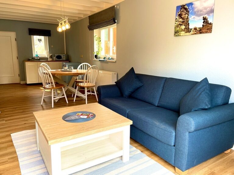 Heller Wohnbereich mit blauem Sofa und Couchtisch
